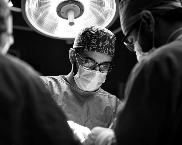 Surgeon in magnifying loupes under an operating light