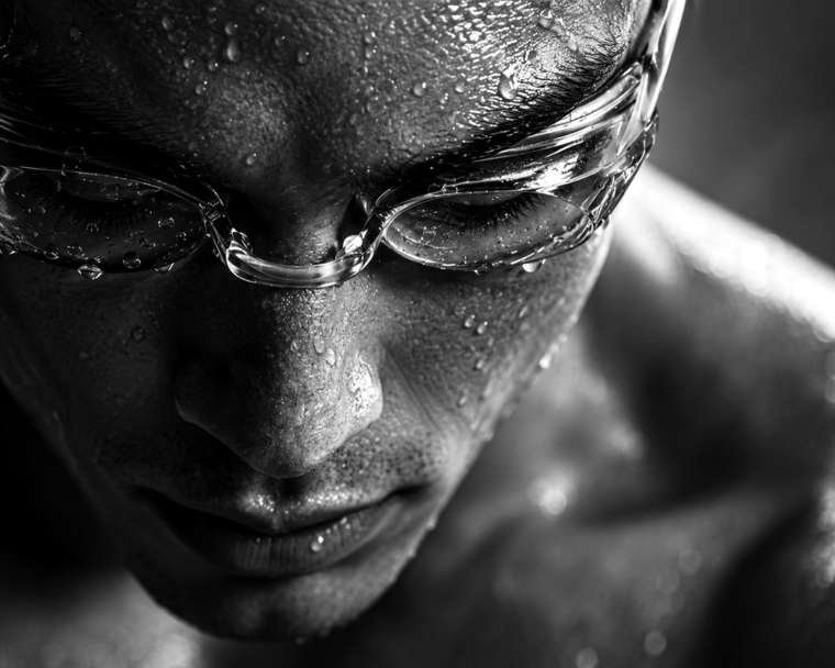 Swimmer in goggles, close up, water on the skin